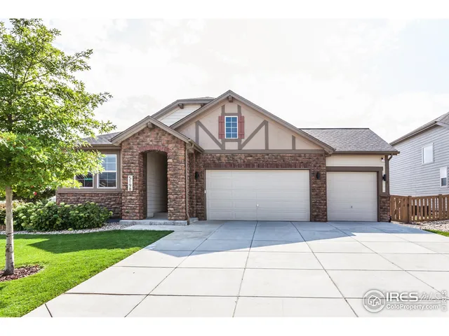 a front view of a house with a yard and potted plants