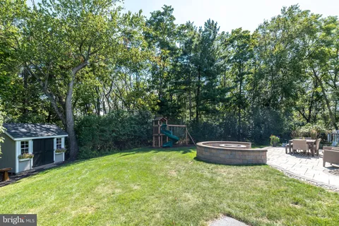 a backyard of a house with fountain table and chairs