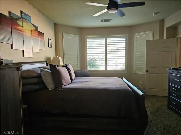 a living room with stainless steel appliances furniture a rug and a large window