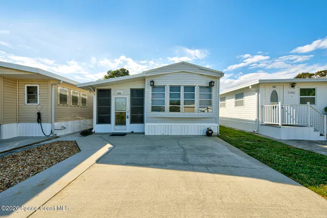 a front view of a house with a yard and glass windows
