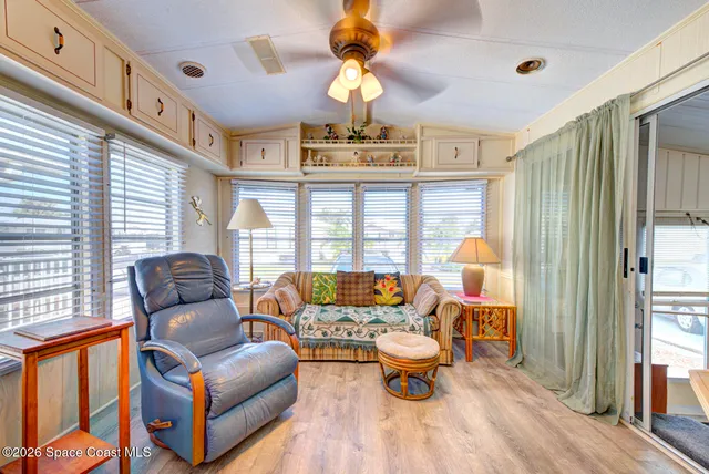 a living room with furniture fireplace and a large window