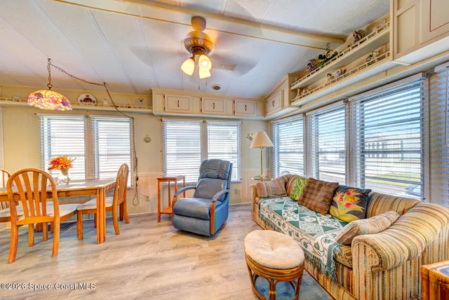 a living room with furniture a chandelier and a dining table