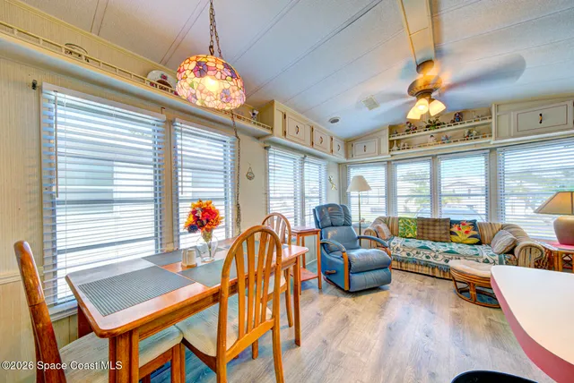 a dining room with furniture a large window and a chandelier