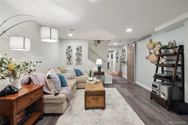a living room with furniture a flat screen tv and a potted plant