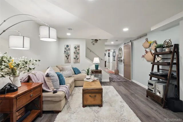 a living room with furniture a flat screen tv and a potted plant