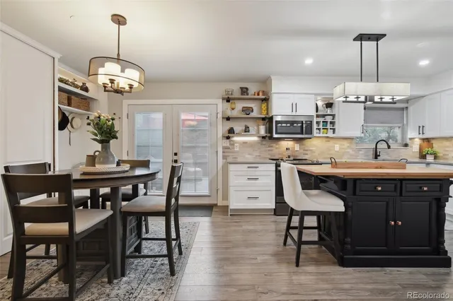 a view of a dining room with furniture a chandelier and wooden floor