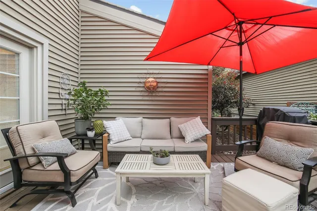 a view of a patio with a table and chairs under an umbrella