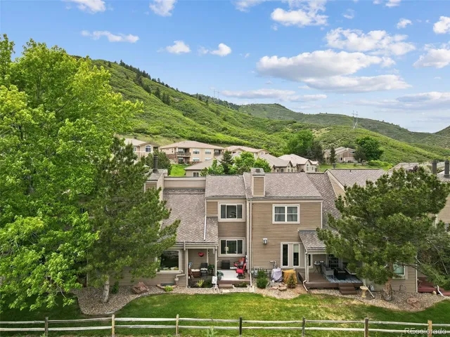 an aerial view of residential houses with outdoor space and trees