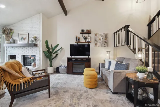 a living room with furniture a fireplace and a flat screen tv