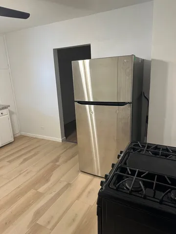 a kitchen with a refrigerator and a stove