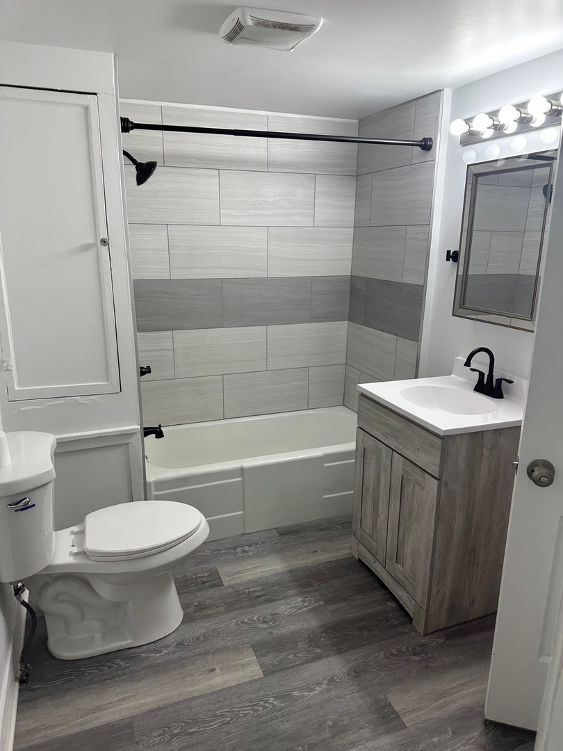 2318 Washington Street, Unit 1 Waukegan, IL 60085 - Photo 8 of 8 a bathroom with a sink a toilet and shower