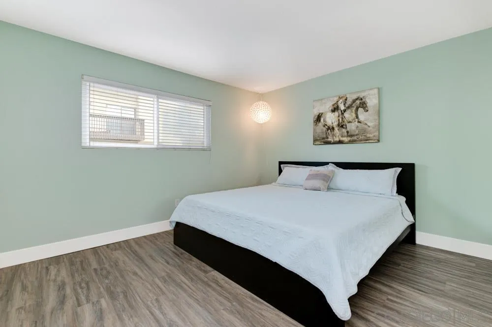 6357 Rancho Mission Road, Unit 1 San Diego, CA 92108 - Photo 15 of 28 a large bed sitting in a bedroom next to a window