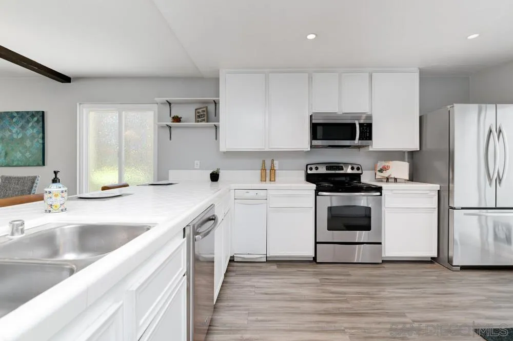6357 Rancho Mission Road, Unit 1 San Diego, CA 92108 - Photo 7 of 28 a kitchen with cabinets stainless steel appliances and wooden floor