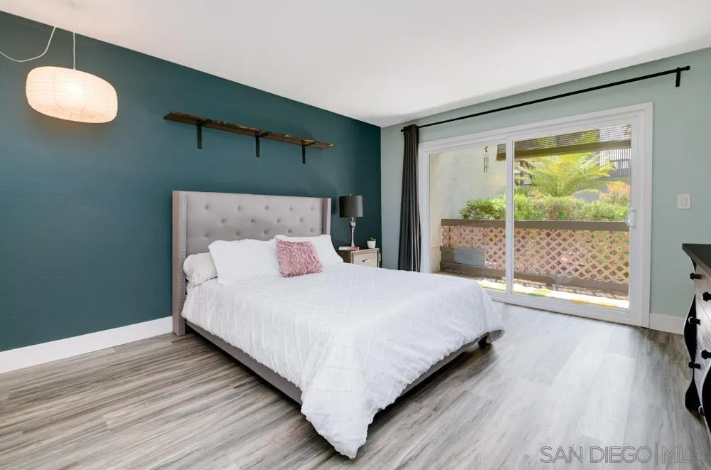 6357 Rancho Mission Road, Unit 1 San Diego, CA 92108 - Photo 10 of 28 a large bed sitting in a bedroom next to a window