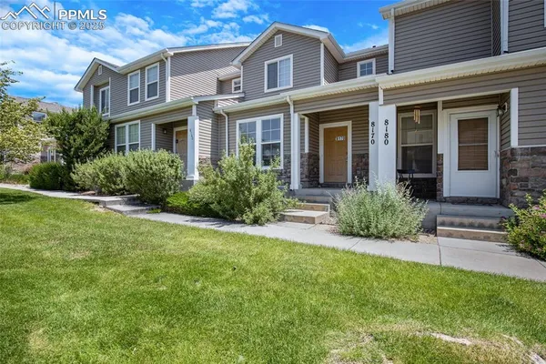 front view of a brick house with a yard