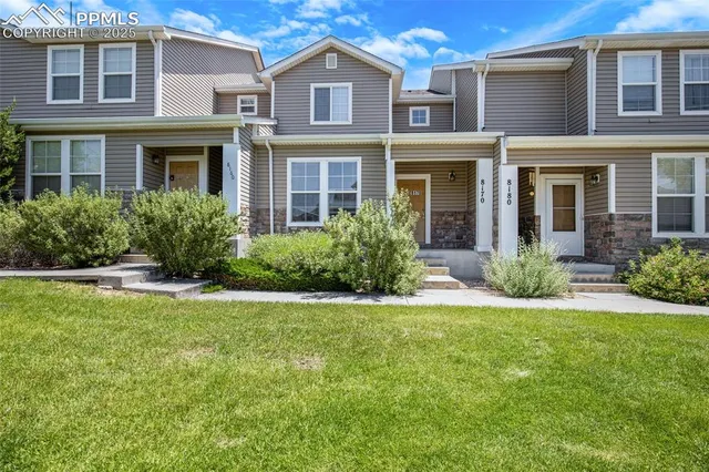 front view of a brick house with a yard