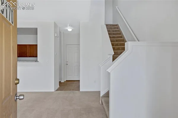 a view of an empty room with wooden floor and entryway