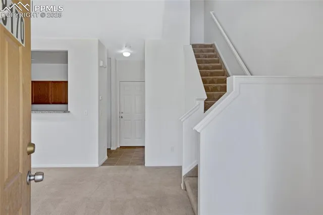 a view of an empty room with wooden floor and entryway
