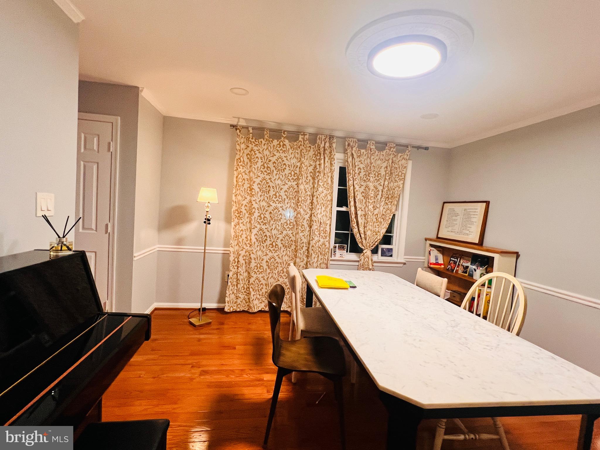 1509 Snughill Court Vienna, VA 22182 - Photo 6 of 12 a living room with a table chairs and a refrigerator