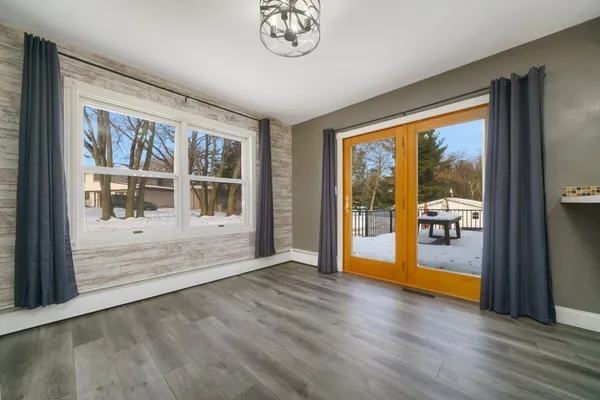 an empty room with an entryway and chandelier fan