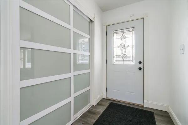 a kitchen with stainless steel appliances granite countertop a refrigerator a sink dishwasher a stove and a dining table with wooden floor