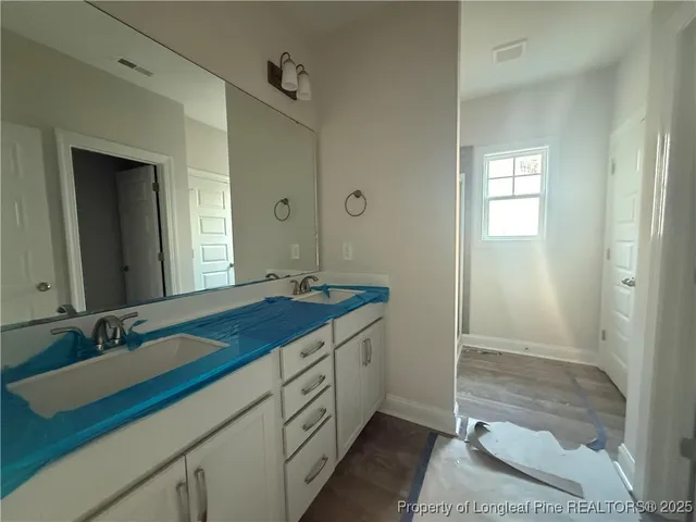 a view of wooden floor and a chandelier fan in a room