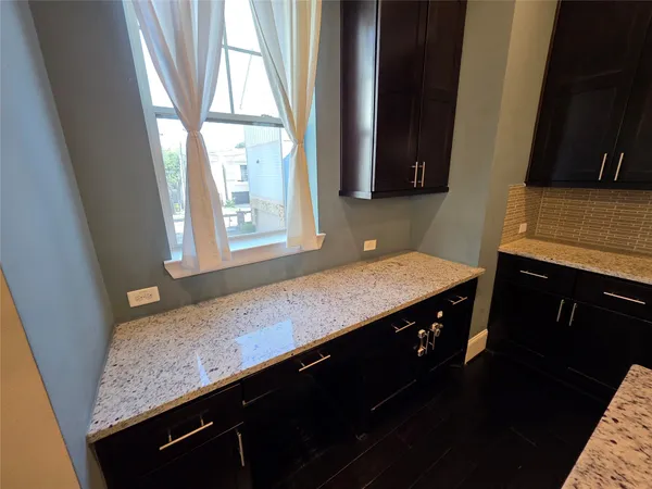 a kitchen with stainless steel appliances kitchen island granite countertop a sink refrigerator and cabinets