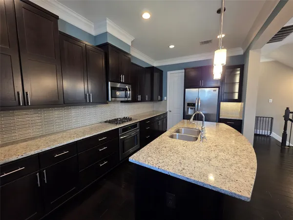 a large kitchen with a table a refrigerator and chairs