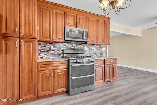 a kitchen with stainless steel appliances granite countertop wooden cabinets a stove top oven