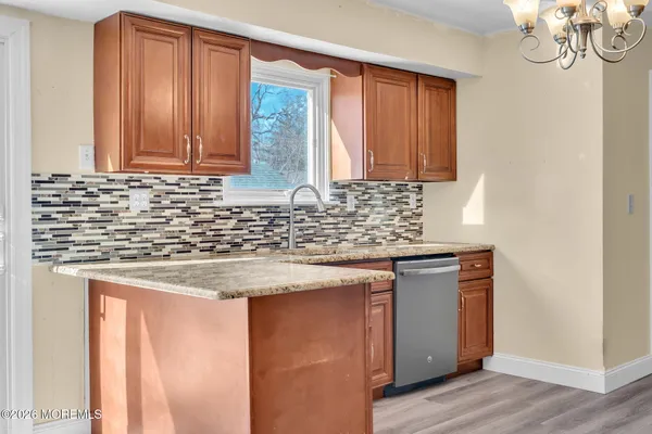 a kitchen with stainless steel appliances granite countertop wooden floors and granite counter tops