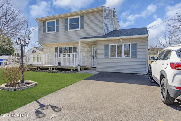 a front view of a house with a garden and yard