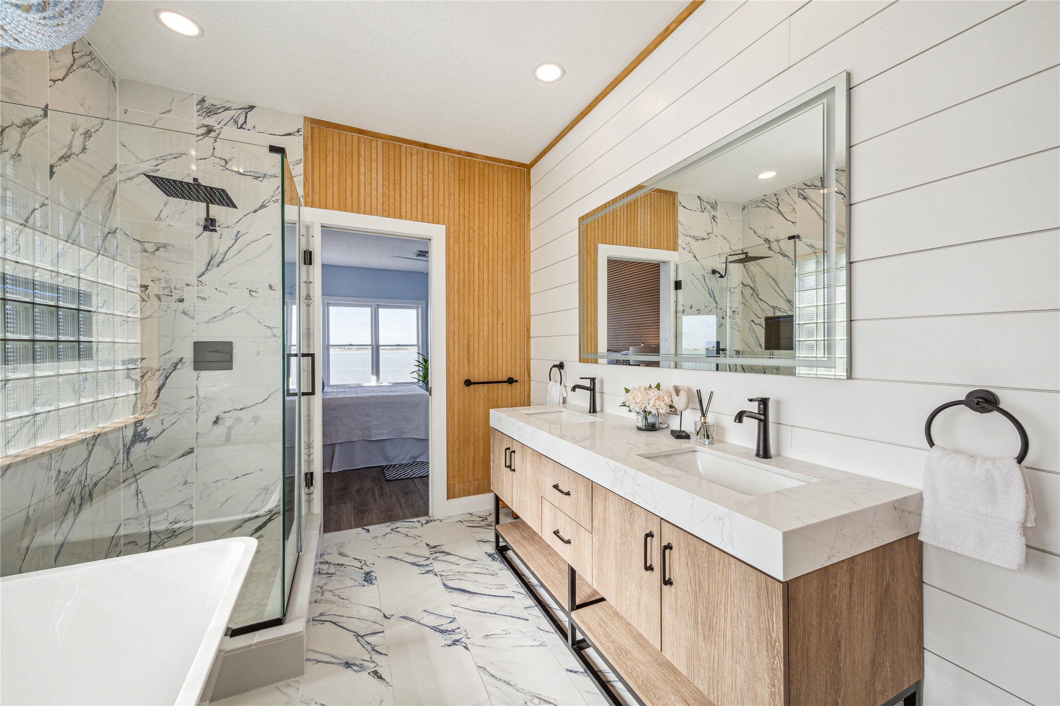 1322 Outrigger Street Tiki Island, TX 77554 - Photo 25 of 46 a bathroom with a double vanity sink a mirror and a bathtub