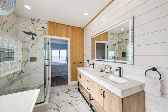 a spacious bathroom with a double vanity sink mirror and bathtub