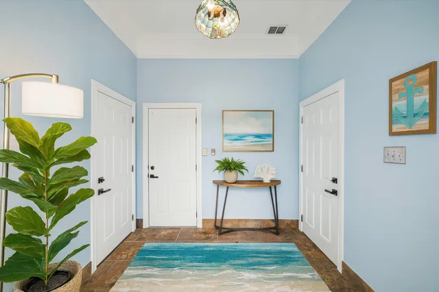 a living room with stainless steel appliances furniture and a potted plant