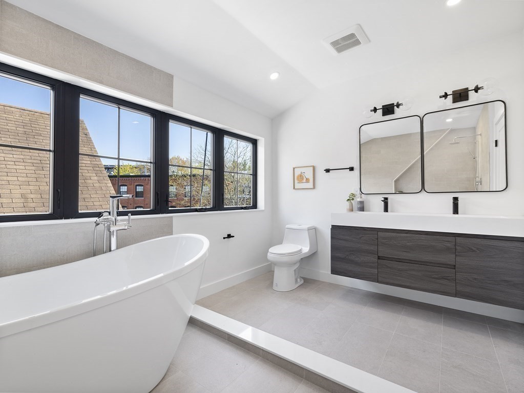 9 B Harrison Road, Unit 9B Somerville, MA 02144 - Photo 16 of 21 a bathroom with a large tub sink toilet and mirror