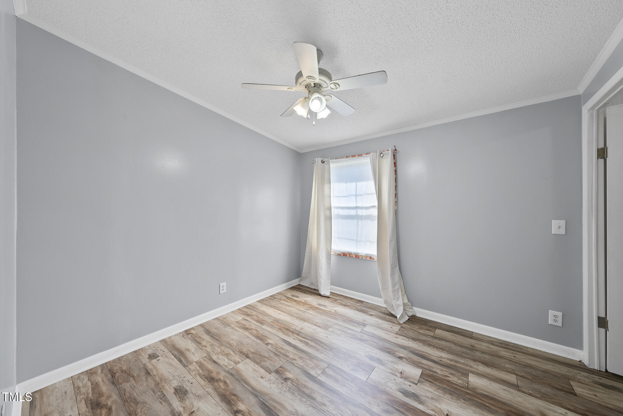 186 Saplin Branch Road Timberlake, NC 27583 - Photo 22 of 46 an empty room with wooden floor fan and windows