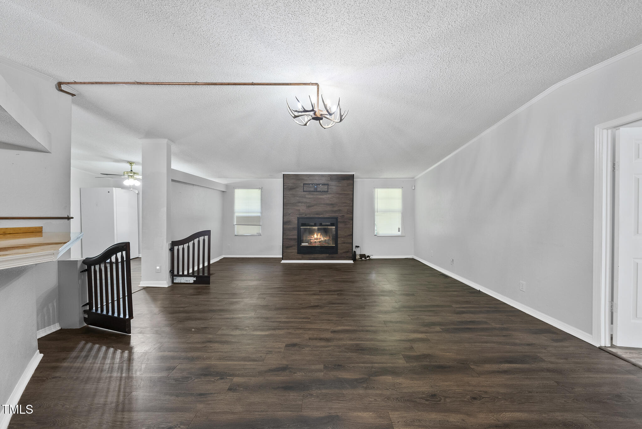 186 Saplin Branch Road Timberlake, NC 27583 - Photo 5 of 46 an empty room with wooden floor fireplace and windows