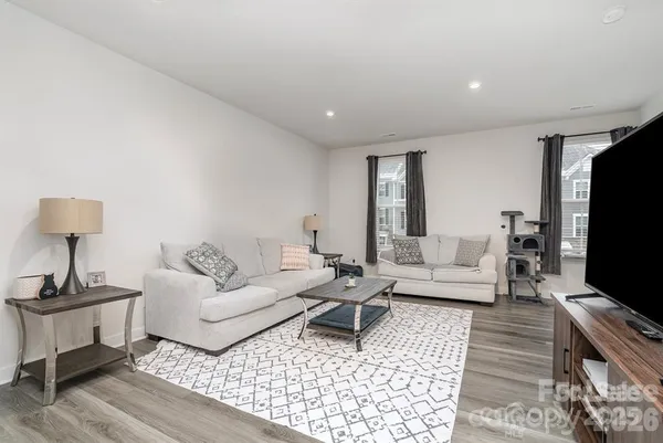 a living room with furniture a flat screen tv and a rug
