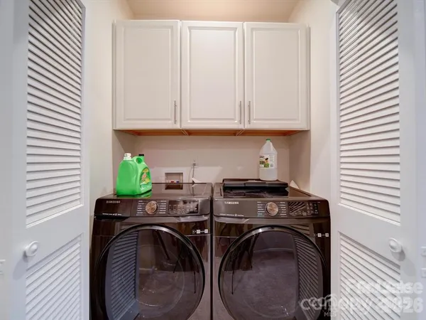 a utility room with stainless steel appliances washer and dryer