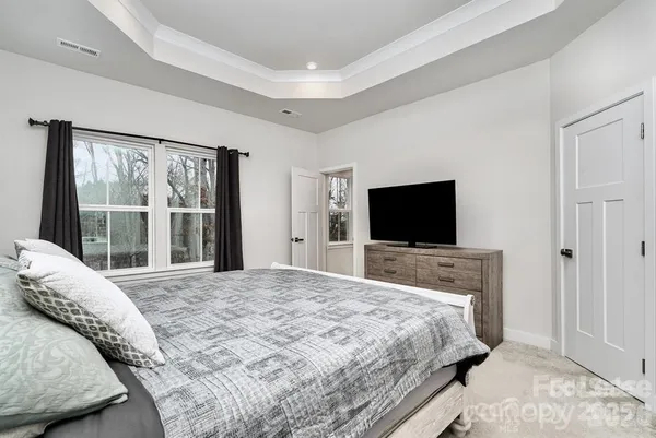 a bedroom with a large bed and a flat screen tv