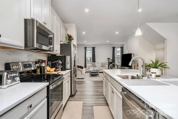a kitchen with stainless steel appliances a sink stove top oven and cabinets