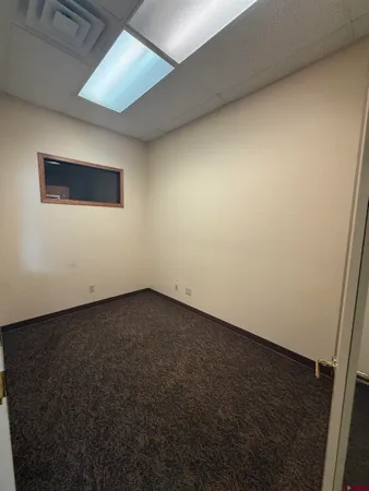 a view of an empty room with wooden floor and closet