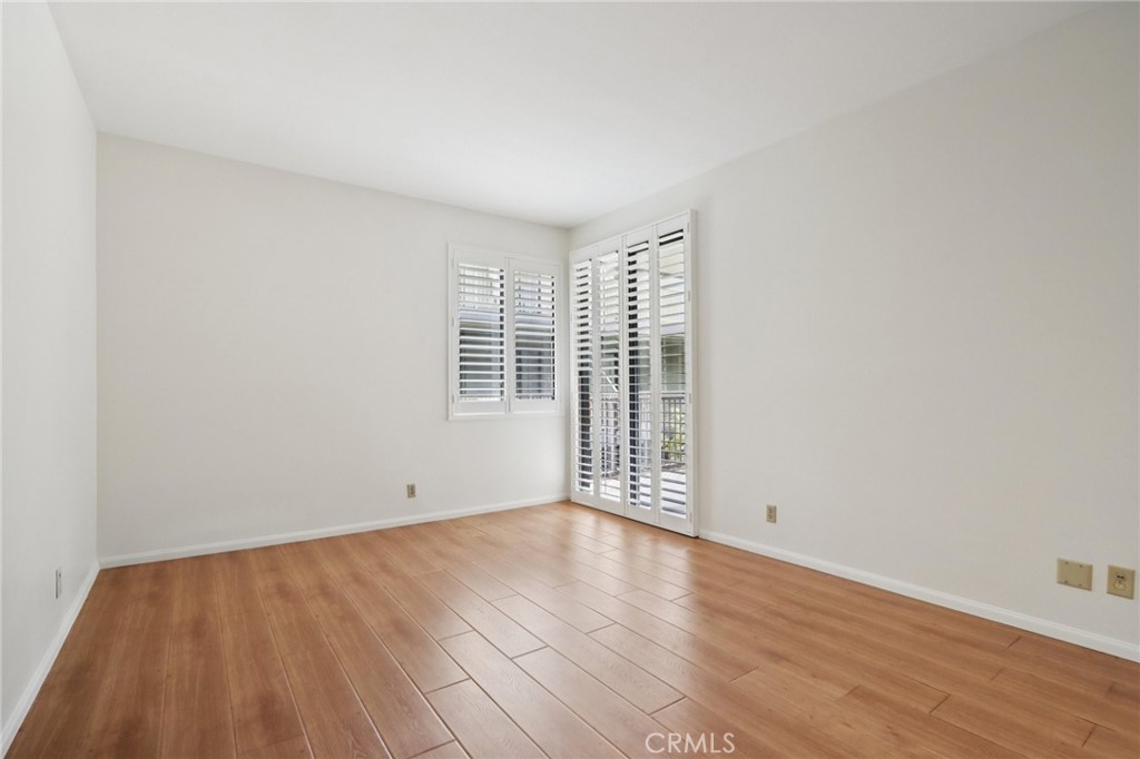 330 Cordova Street, Unit 257 Pasadena, CA 91101 - Photo 14 of 28 an empty room with wooden floor and windows