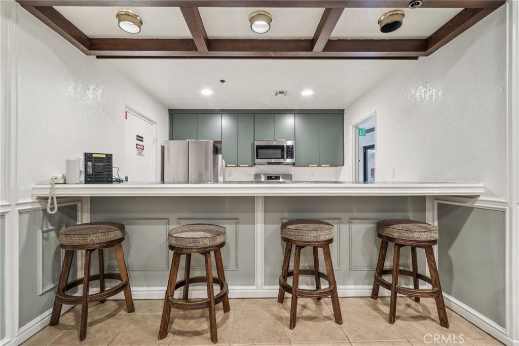 330 Cordova Street, Unit 257 Pasadena, CA 91101 - Photo 20 of 28 a kitchen with stainless steel appliances granite countertop a table chairs sink and cabinets