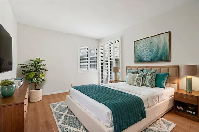 a bedroom with a bed potted plant with the window