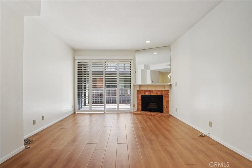 330 Cordova Street, Unit 257 Pasadena, CA 91101 - Photo 5 of 28 an empty room with wooden floor fireplace and windows