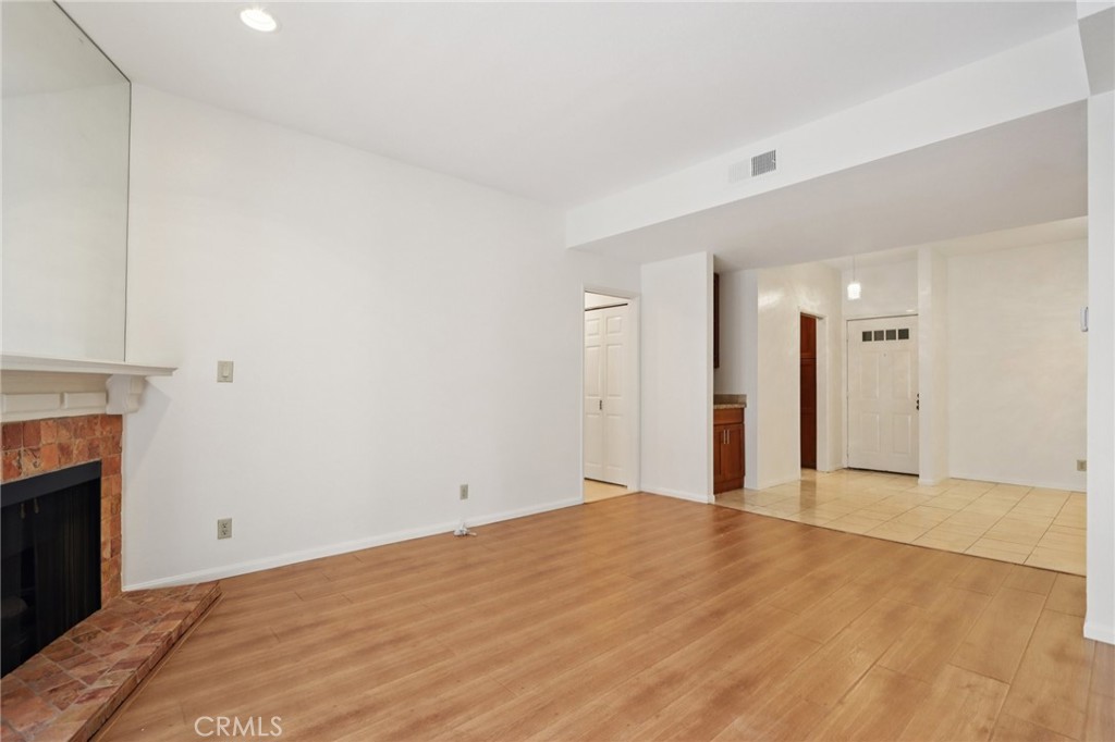 330 Cordova Street, Unit 257 Pasadena, CA 91101 - Photo 8 of 28 a view of an empty room with wooden floor and a fireplace