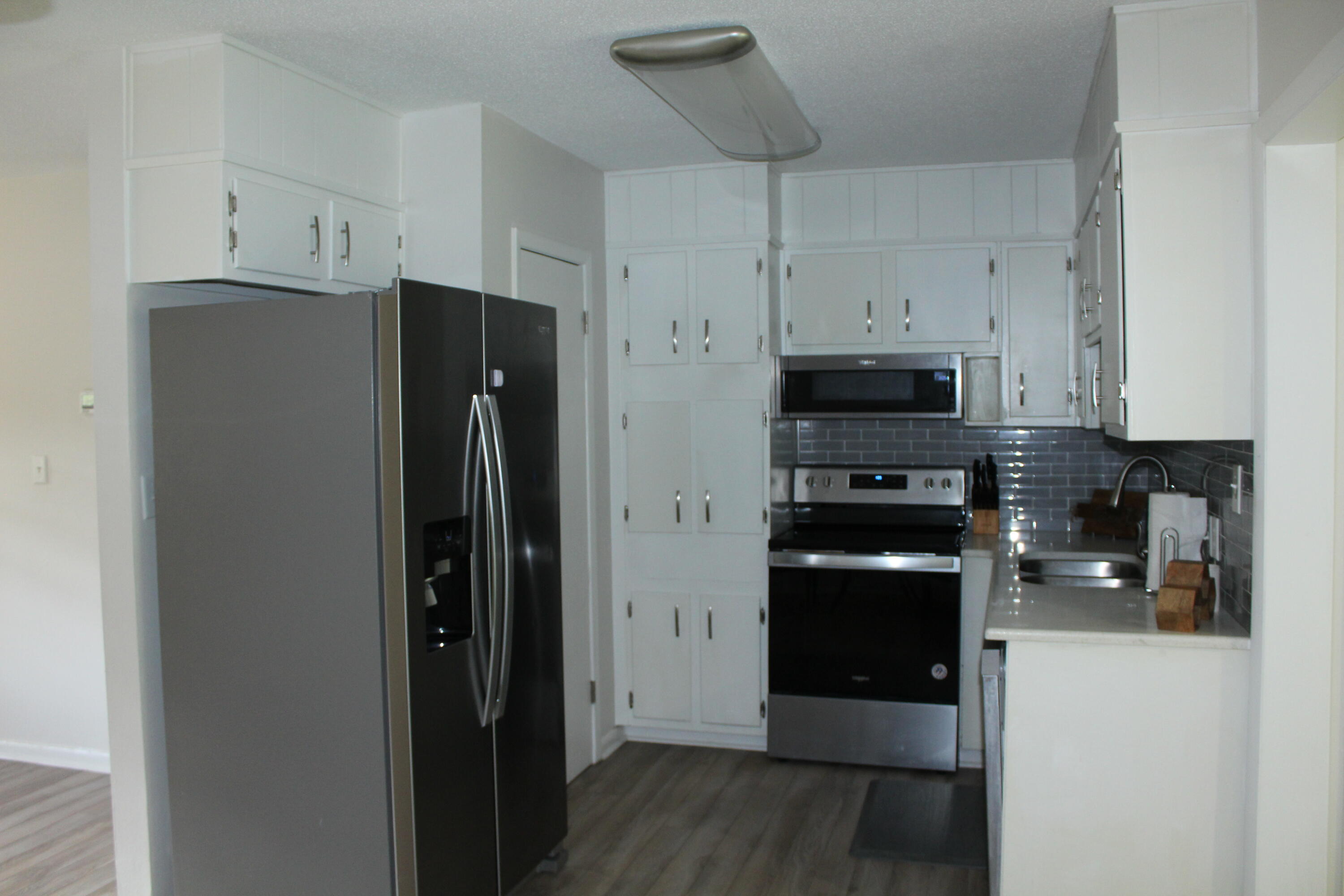 313 Brackin Street, Unit A Crestview, FL 32539 - Photo 5 of 27 a kitchen with stainless steel appliances a refrigerator and a stove top oven