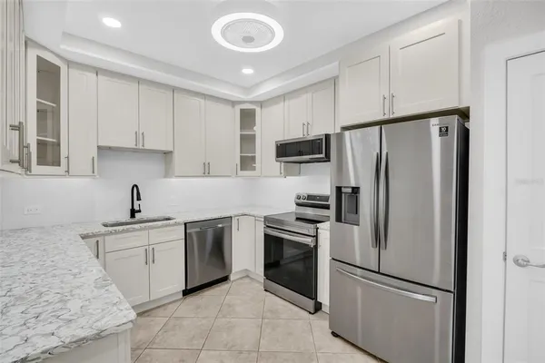 a kitchen with a refrigerator sink and white cabinets