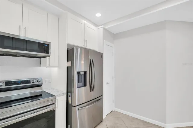 a metallic refrigerator freezer sitting in a kitchen